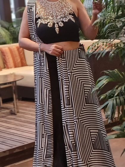 This outfit is all about versatile styling. Here, I'm showing how this black skirt and embellished halter blouse can be paired with a geometric print drape to create a modern saree look.