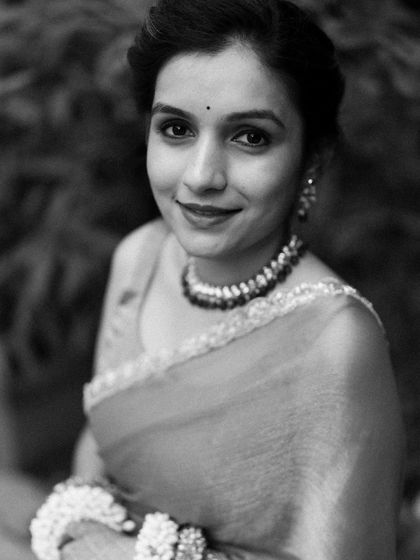 A timeless black and white portrait of a bride, her gentle smile and traditional attire creating an image of pure elegance.