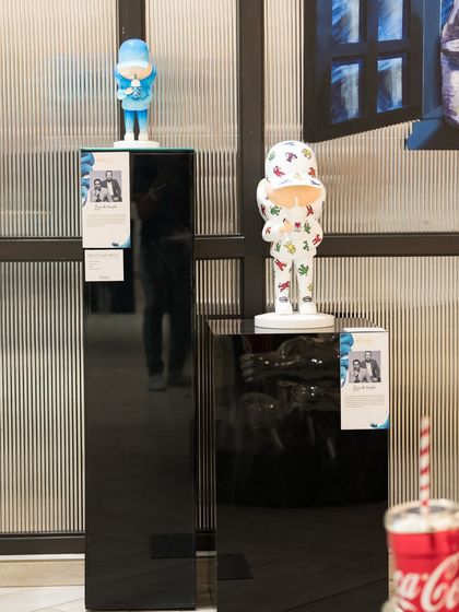 The 'Kid Cup' sculptures by Leo and Steph displayed on our signature black plinths. Their work, known for its playful nostalgia, has taken the art world by storm.