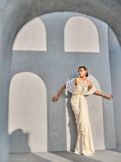 An ethereal ivory gown combining embellished mesh with dramatic structured sleeves and a fluid, draped bottom. A symphony of couture craftsmanship where every detail speaks of luxury.