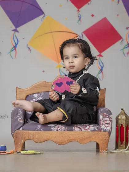 A thoughtful pose during the kite festival photoshoot. The props, including a lantern and pearl necklace, add a touch of elegance to the traditional theme.
