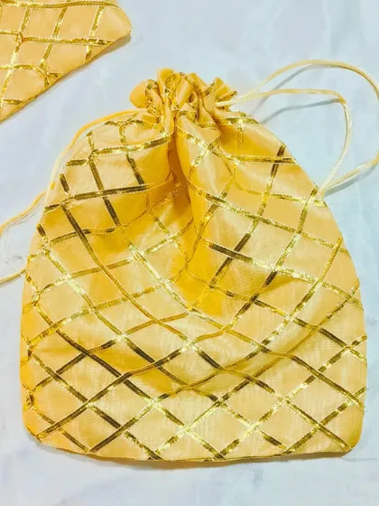 This yellow potli bag with a gold lattice design is another vibrant and traditional choice for your gift packaging needs.