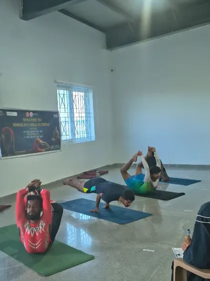 Participants demonstrate advanced asanas during a session at the SVYASA Conference, showcasing incredible flexibility and control.