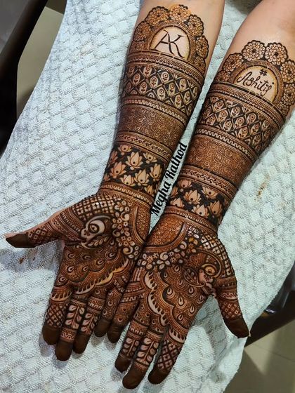 A stunning example of personalized engagement henna, this design incorporates the couple's initials 'AK' and name 'Kshitij' into the intricate wristbands.
