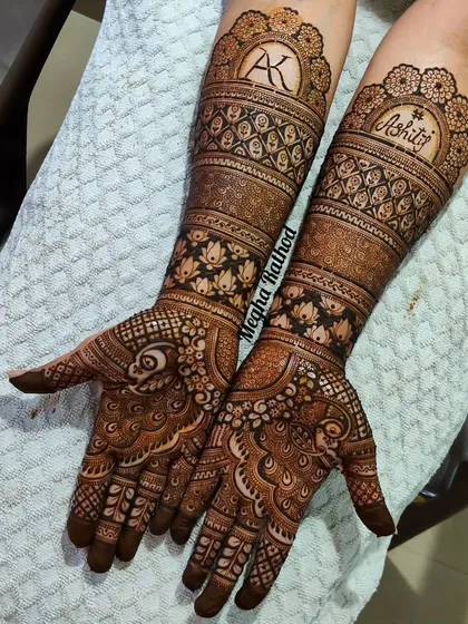 A stunning example of personalized engagement henna, this design incorporates the couple's initials 'AK' and name 'Kshitij' into the intricate wristbands.