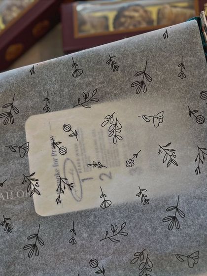 A close-up of the custom tissue paper and personalized sticker for a Roka order. These small, bespoke details are part of what makes the gifting experience so special and unique.