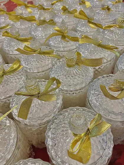 A still shot of our crystal jar candles with gold ribbons, showcasing their classic and elegant appeal. They are a timeless choice for wedding return gifts.