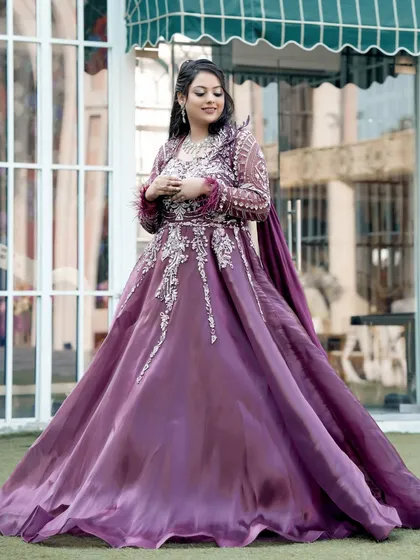 A full-length portrait of the bride, her magnificent gown flowing around her, capturing a moment of quiet grace.