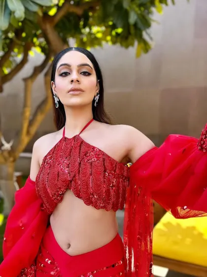 A powerful pose in the red gala outfit. The styling is all about creating a look that is both artistic and fashionable.