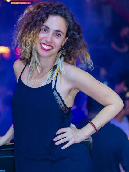 A guest with beautiful curly hair, smiling for the camera.