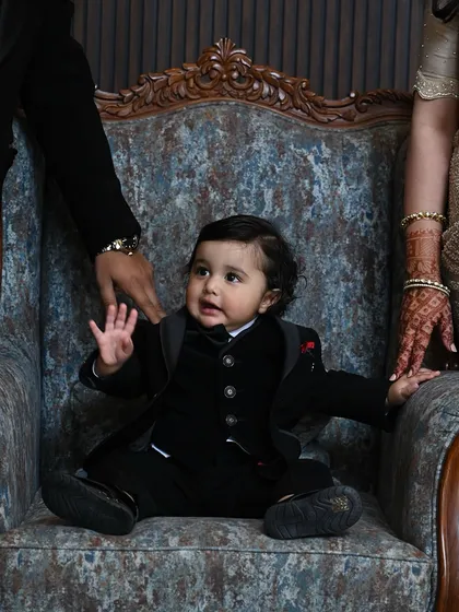 A precious moment captured. This tiny tuxedo is perfect for a family wedding, ensuring the youngest members of the party are just as stylishly dressed.