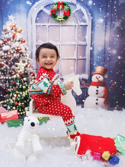 A full view of the winter wonderland setup, with a happy toddler riding a rocking horse by the Christmas tree.