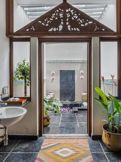 The Vasishta suite's bathroom, with its stone-carved vanity and view to a private courtyard, is a perfect example of our blend of rustic and refined.