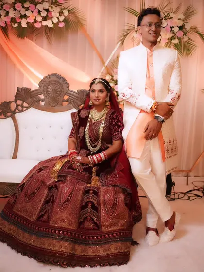 A classic wedding portrait of the couple seated on the stage, looking like royalty.