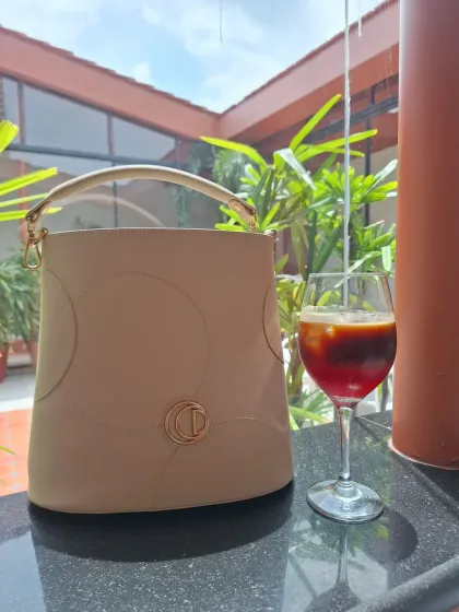 A product shot of the elegant Oceedee Jade Bag, paired with a refreshing drink.