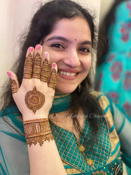 A happy client with her mandala and bracelet-style mehendi. This is a modern and stylish choice for any celebration.