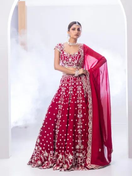 For the bride who loves tradition with a touch of modern grace, I present this reimagined red lehenga. The intricate contrast embroidery and classic A-line silhouette offer a timeless look, while the thoughtful detailing ensures it feels fresh and personal for your most important day.
