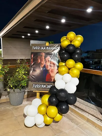 "Tussi jaa rahe ho? Tussi na jao!" We love adding a touch of Bollywood drama to our decor, like this iconic poster for a farewell party, complete with a black, white, and gold balloon garland.