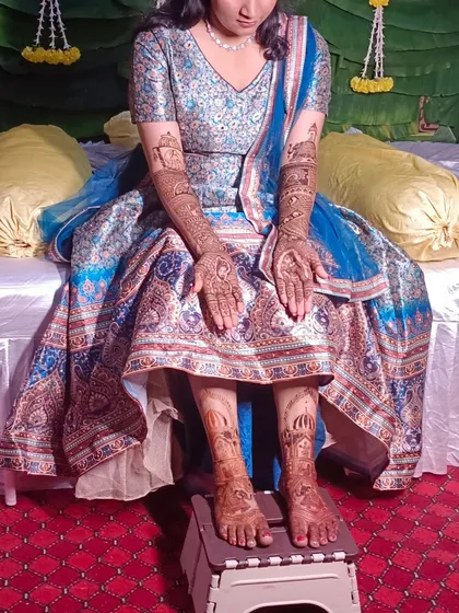 A full-length shot of the bride, showing how the mehendi on her hands and feet completes her entire bridal look.