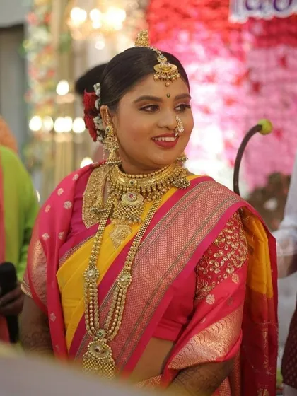 A candid shot of our happy Maharashtrian bride during her wedding ceremony. The makeup is traditional and radiant, highlighting her joyful expression.
