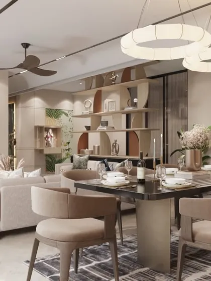 This open-plan living and dining area flows effortlessly, defined by sculptural lighting and a palette of soft neutrals and rust tones. The custom shelving unit acts as a functional art piece, dividing the space while maintaining an open feel.