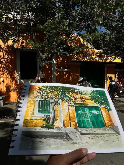 My sketchbook page against the real-life orange and yellow building in Pondicherry. A perfect match.