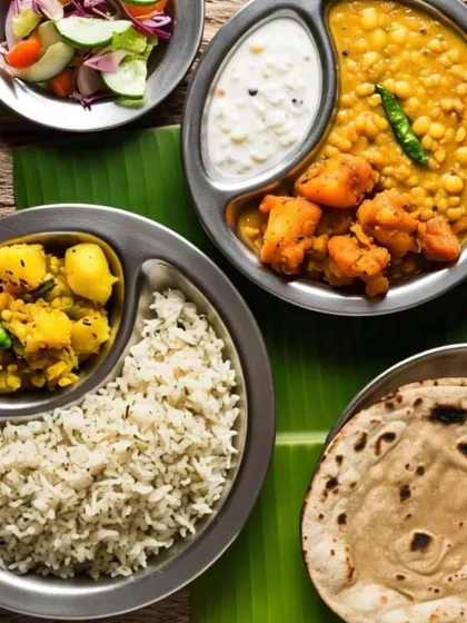 A simple yet fulfilling thali served on a traditional banana leaf. This meal includes steamed rice, aloo sabzi, a hearty dal, cooling raita, soft rotis, and a side of fresh salad.
