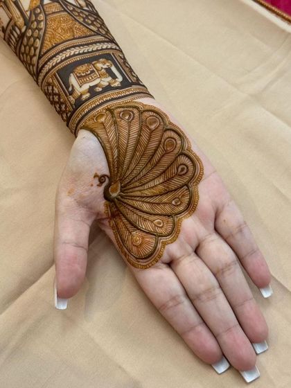 A bold and beautiful peacock design where the bird's feathers fan out to cover the entire palm. The forearm features traditional elephant and palace motifs.