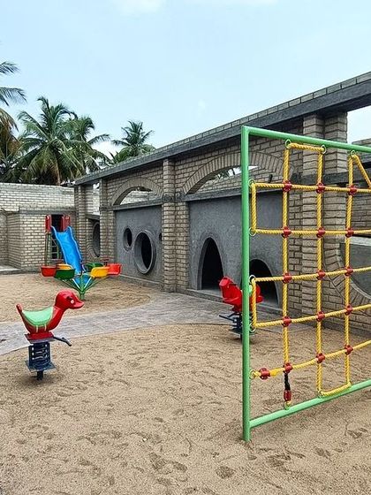 The playground at Sai Kirupa Special School, set within a courtyard framed by arched corridors. We designed this as a safe and stimulating environment for children with special needs, with sand pits and accessible play equipment.