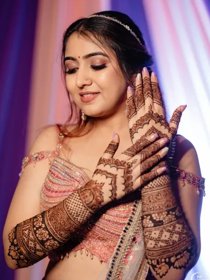 A client admiring her full-arm mehndi, a design rich with traditional patterns and clean, crisp lines.