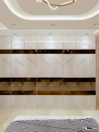 A full view of a spacious bedroom, highlighting the large, high-gloss wardrobe with a geometric gold and marble pattern. The design is clean, luxurious, and offers ample storage.