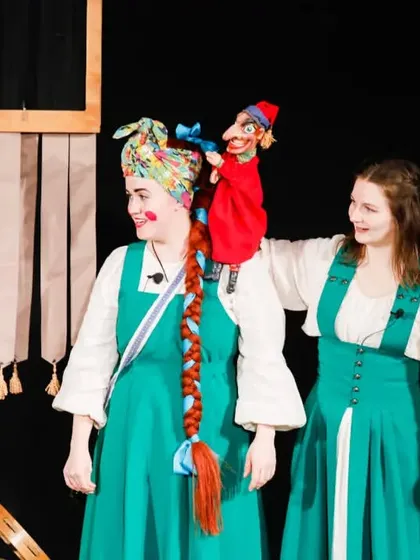 The performers of 'Petrushka' interact with the main puppet character, blending live performance and puppetry seamlessly.