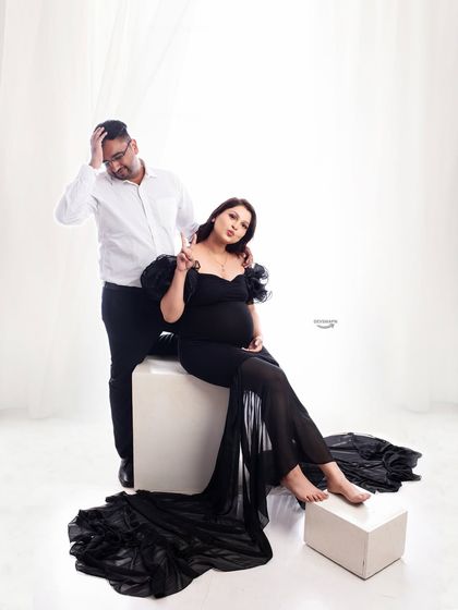 A fun and candid moment during the shoot. The partner's playful reaction adds a touch of humor and personality to this stylish couple's maternity portrait.
