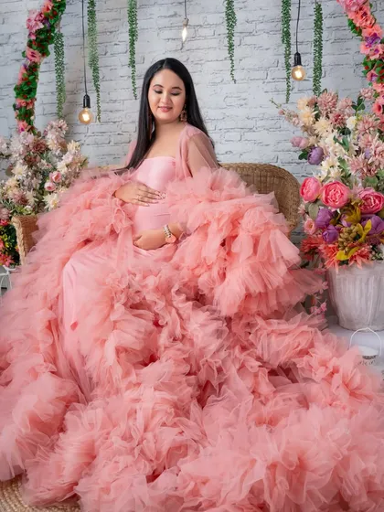 A seated portrait in the pink ruffled gown, creating a look of being enveloped in a cloud of soft tulle.