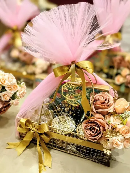 For Diwali, I love creating hampers that feel both festive and elegant. This metal basket hamper, wrapped in soft pink tulle and adorned with faux roses, is filled with gourmet goodies and makes for a beautiful and reusable gift.