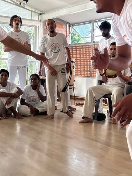 A friendly game in the roda during the Batizado. The smiles and connection between players show that Capoeira is about joy and communication.