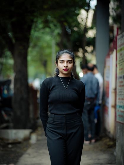 A classic portrait pose with hands behind the back. It creates a clean, elegant look that focuses on the subject's face and expression.