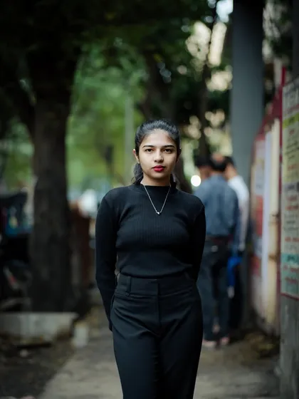 A classic portrait pose with hands behind the back. It creates a clean, elegant look that focuses on the subject's face and expression.