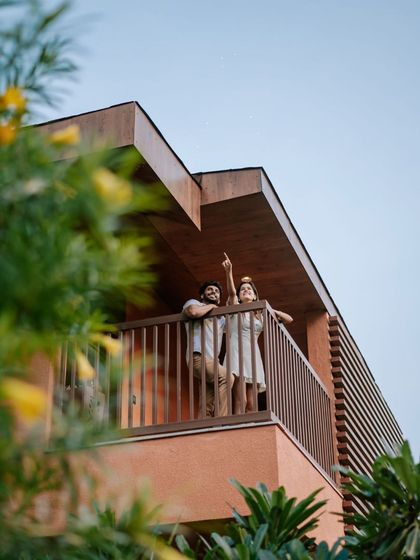 A couple enjoys an evening on their private balcony, pointing up at the stars. The clear skies away from the city offer a perfect opportunity for stargazing and creating romantic memories.