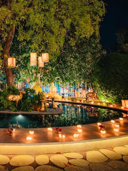 The serene ambiance of the Sunderkand event at night. The garden was lit with hundreds of candles and diyas around a water body, creating a tranquil and spiritual atmosphere.
