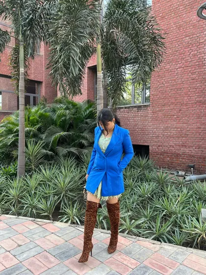 This shot shows how the long blazer and high boots work together to create a balanced, high-fashion silhouette that's still wearable for a day out in the city.