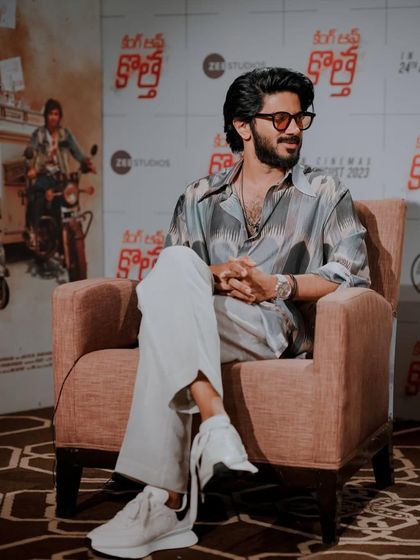 Seated for an interview, the unique print of Dulquer's shirt is the main focus. It’s a great conversation starter.