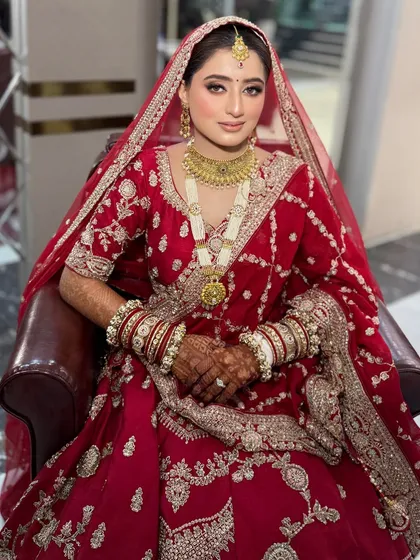 A full portrait of the bride seated in the salon chair. This shows the complete look just before she heads out for her big day.