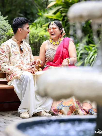 A candid photo of the couple sharing a laugh by a fountain during their Mehendi ceremony. These natural interactions make for the best pictures.