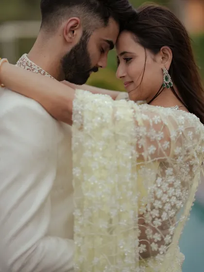 A candid moment of dance and movement during an engagement shoot in Mumbai. The natural light and the couple's interaction create a dynamic and romantic image that feels alive.