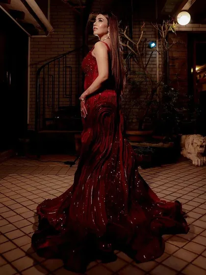 For a look that is pure glamour and drama, I present this sculpted red mermaid gown. The intricate texture and deep crimson color create a powerful statement, while the flared train adds a touch of classic elegance. This is an ideal choice for an evening reception or a high-fashion photoshoot.