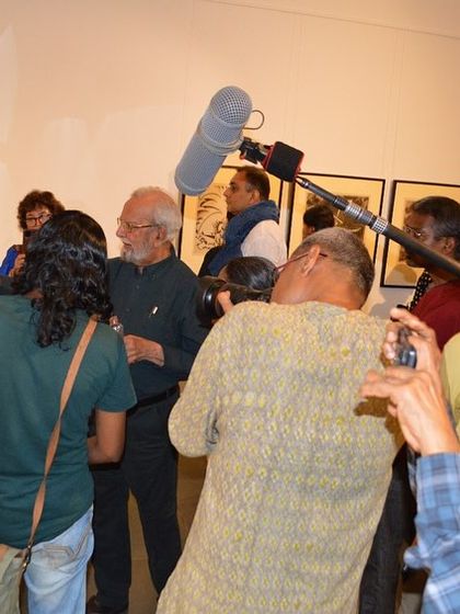 The press and visitors capturing the moment as the artist speaks.