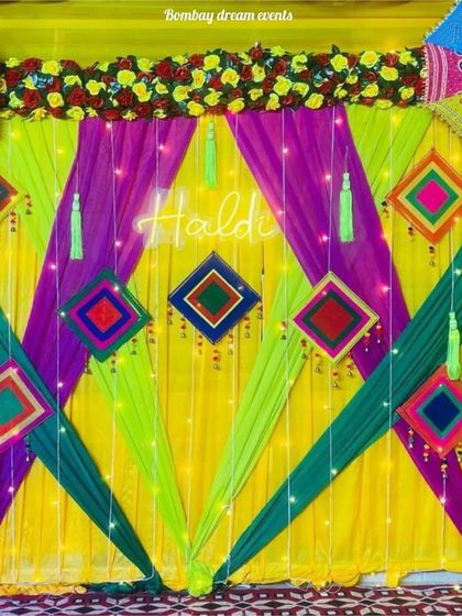 This Haldi backdrop combines bright drapes with a central neon sign and traditional hangings for a modern yet festive look.