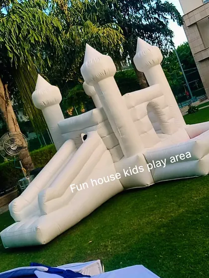 An angled shot of our white 4-in-1 castle on a grassy field, highlighting its impressive turrets and slide.