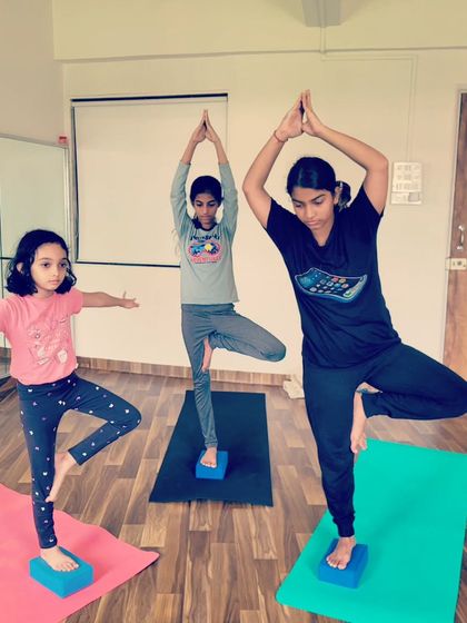 Finding balance and focus in tree pose. Using blocks under their feet gives these young yogis a stable foundation to grow tall and steady.